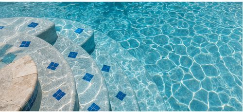 Close-up of blue waterline tile and stone coping on a Lowcountry pool.